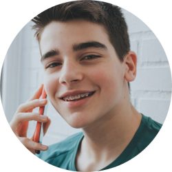 teenage guy with braces on the phone